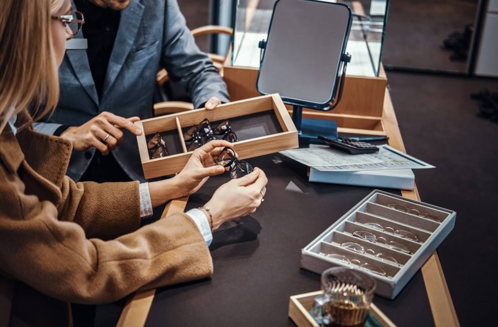 An optometrist goes over JMM unique design features with a patient while they browse for frames.